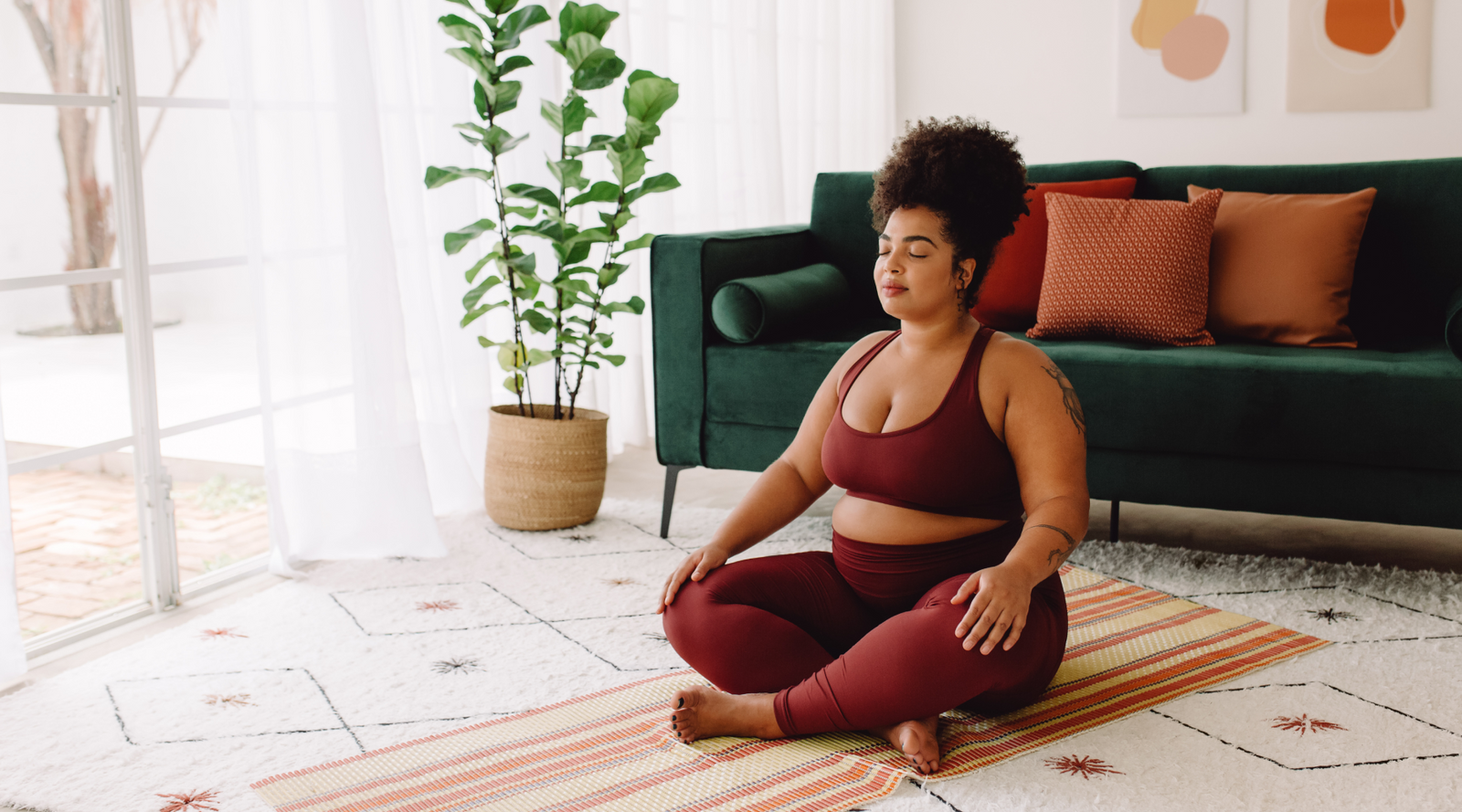 Man and woman in athletic gear stretching on yoga mats in a living room