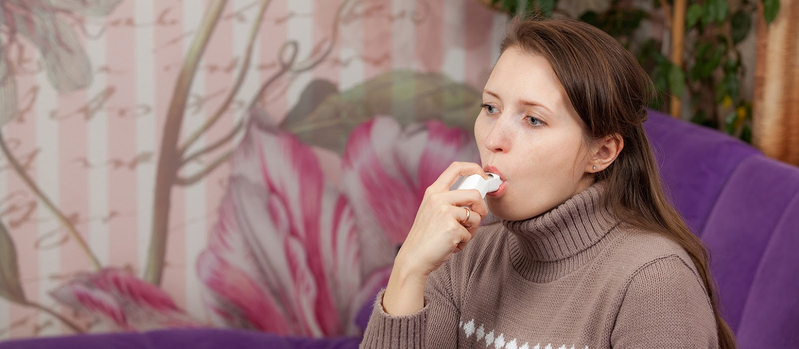 Woman who suffers from asthma using an inhaler