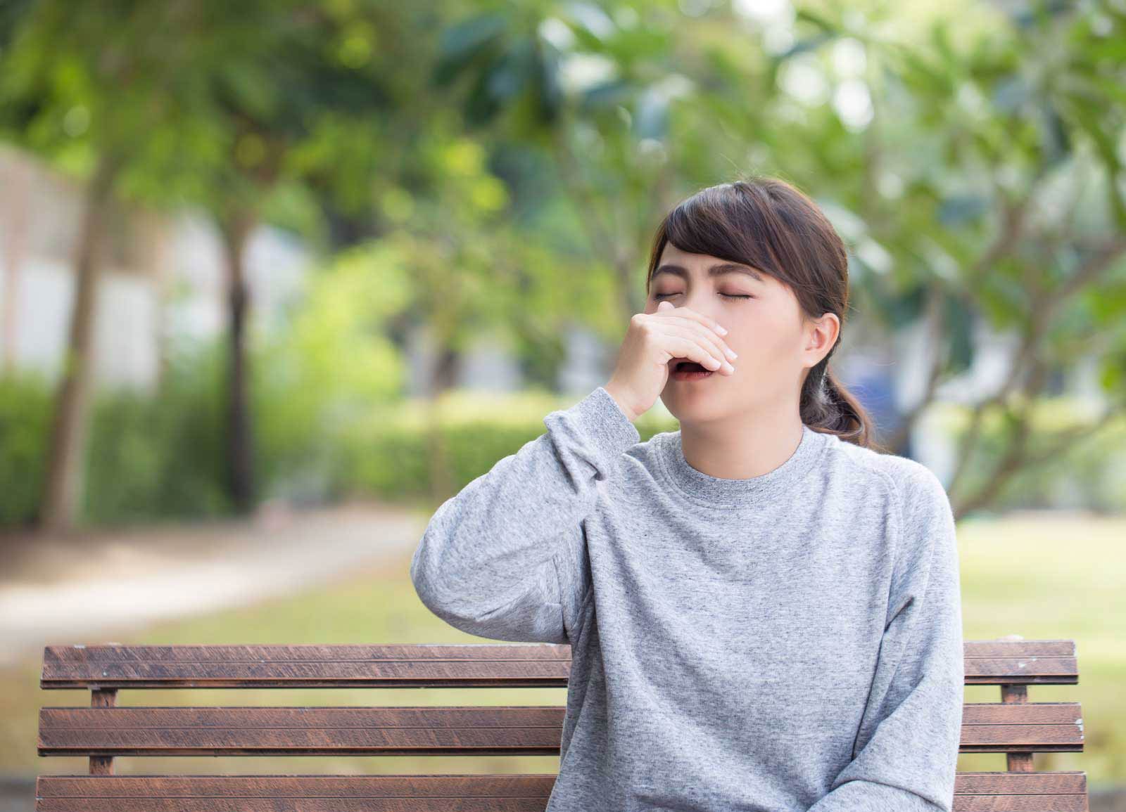 Woman sneezing from seasonal allergies