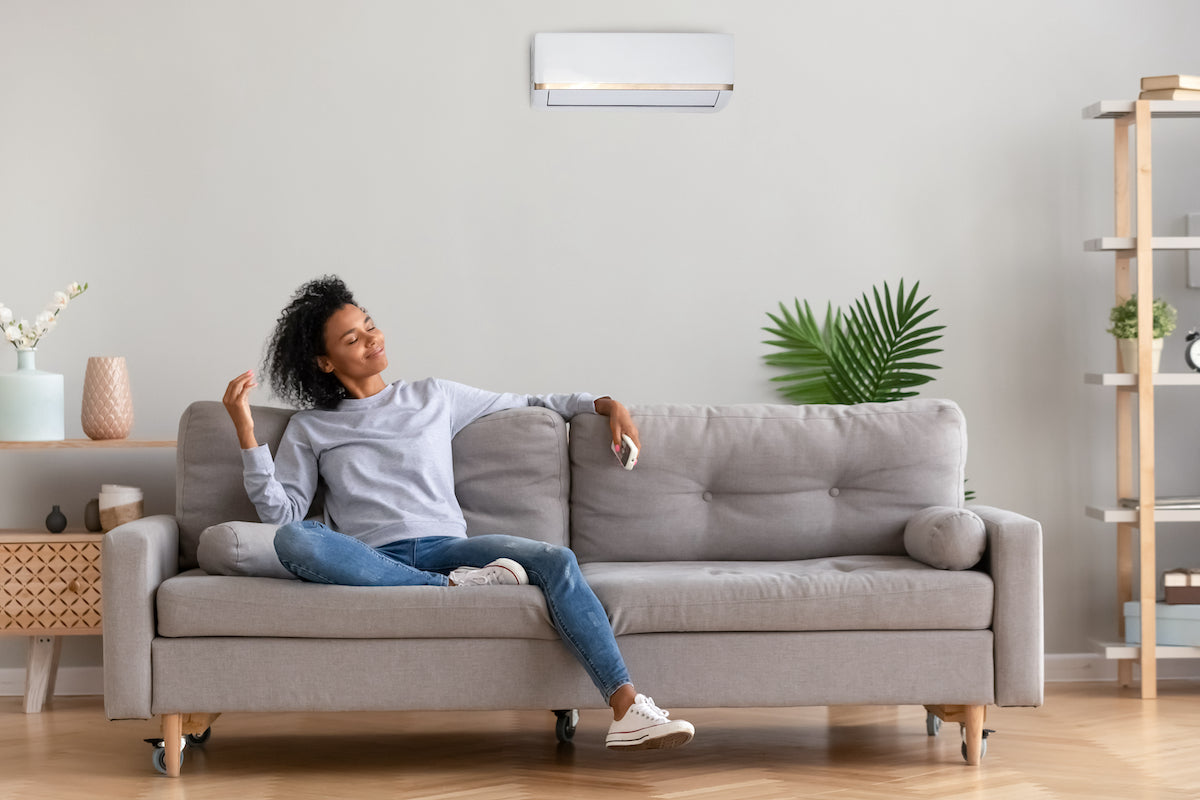 Woman lounging on gray sofa in a modern living room