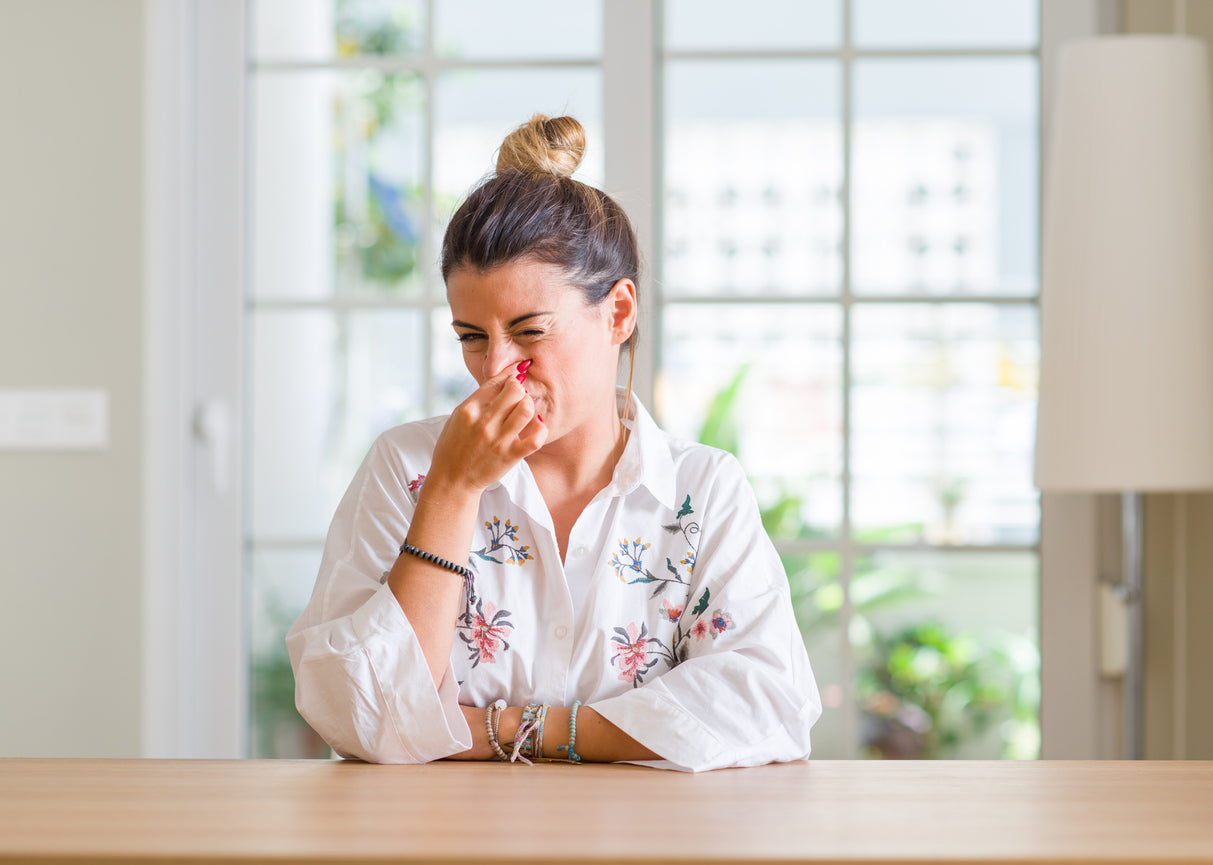woman holding nose stale air
