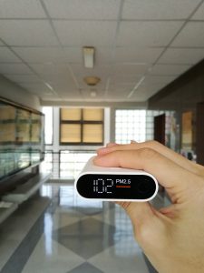PM2.5 monitor in a hand in a hall