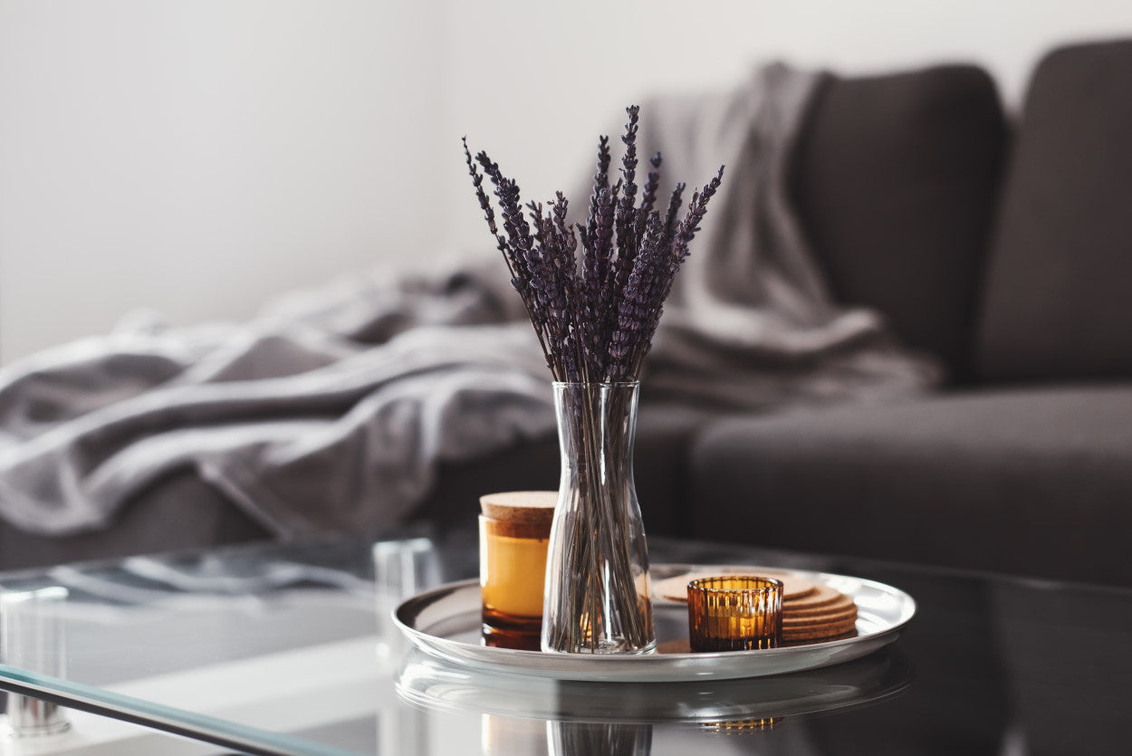 Dried lavender in a vase with candles and coasters