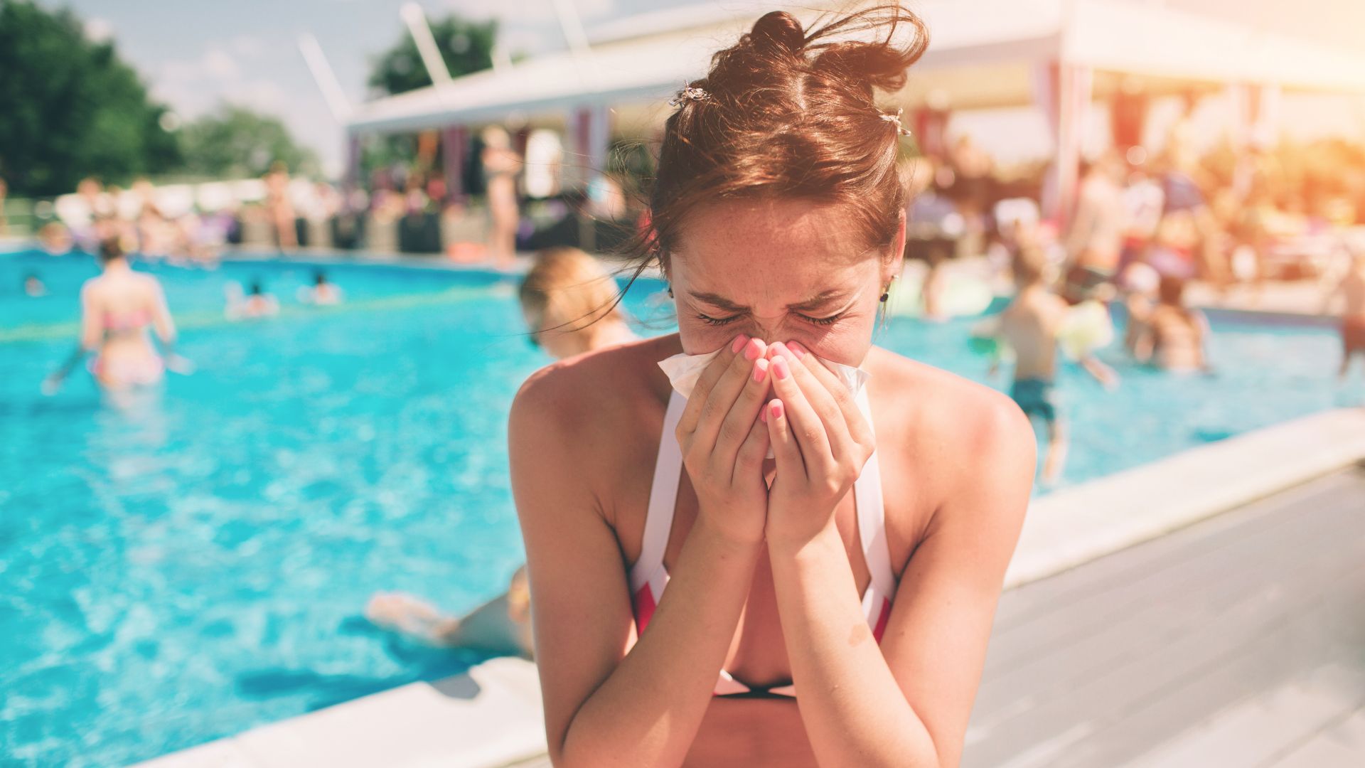 Girl blowing her nose outside of community pool | Air Purifiers for Allergies | Molekule