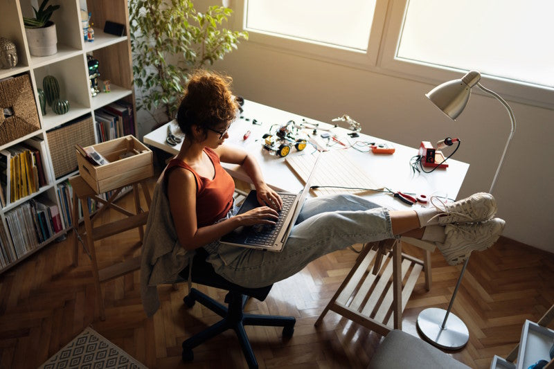 Woman working on laptop with her feet up on a desk