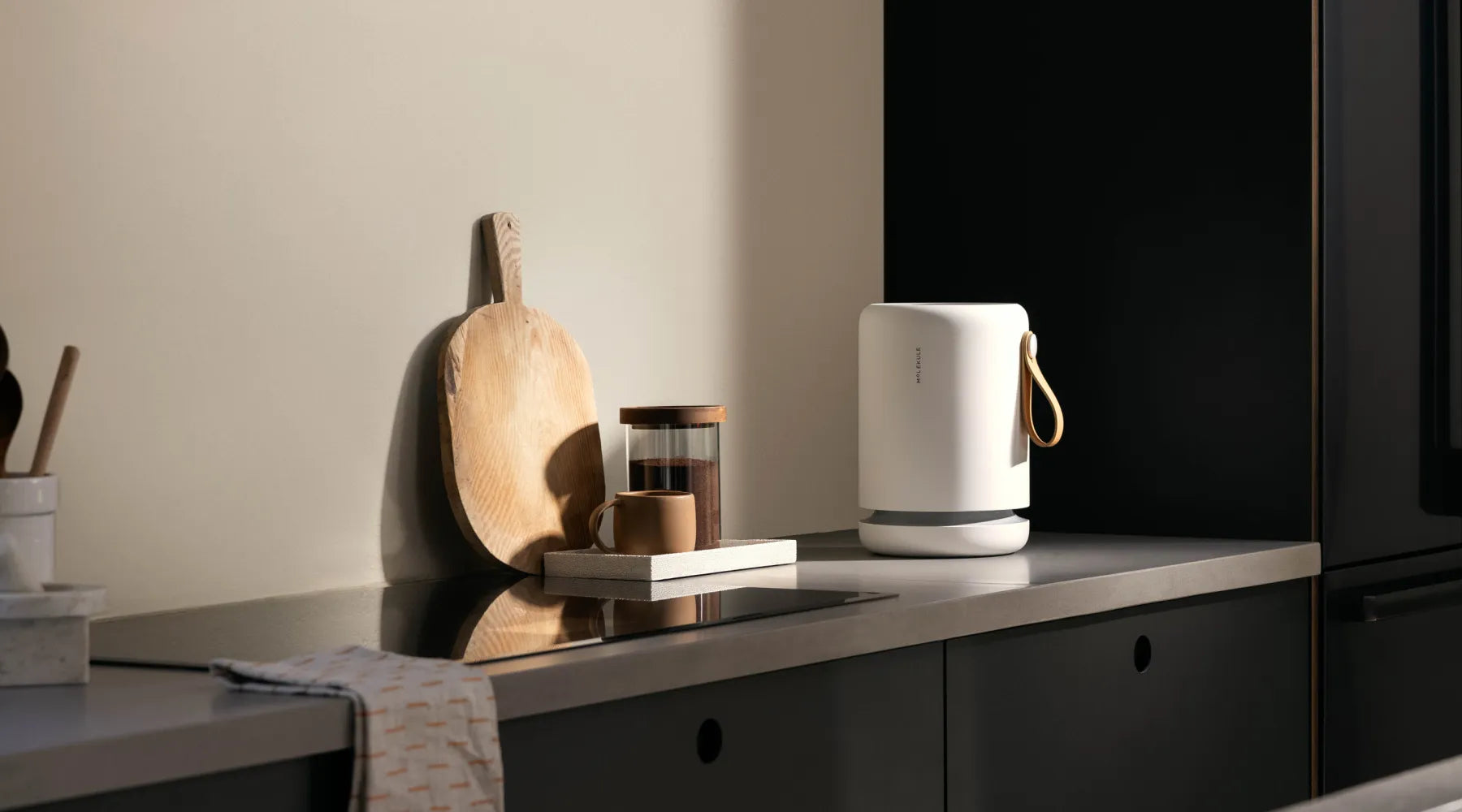 Molekule Air Mini+ sits on a kitchen counter with various small appliances and kitchen gadgets.
