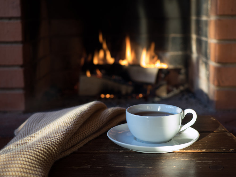 Cup of coffee with a fireplace in the background