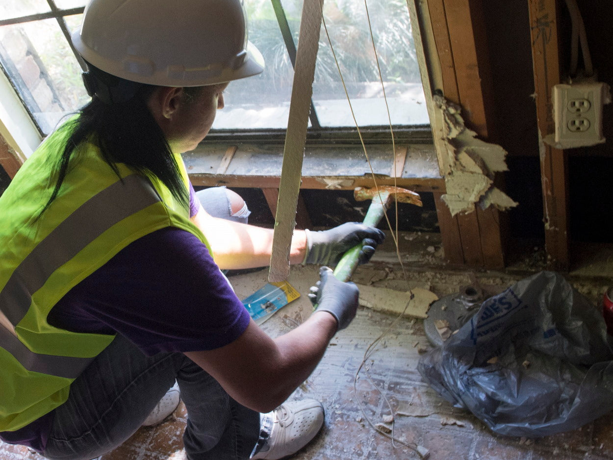 Worker repairing window after hurricane damage