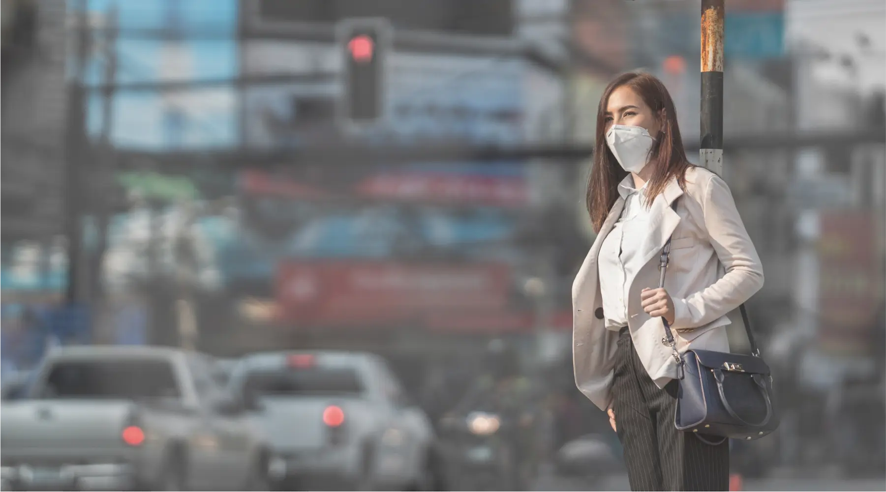 Woman wearing N95 mask standing on smoggy city street