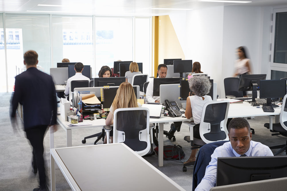 A busy office with people working at desks in cubicles