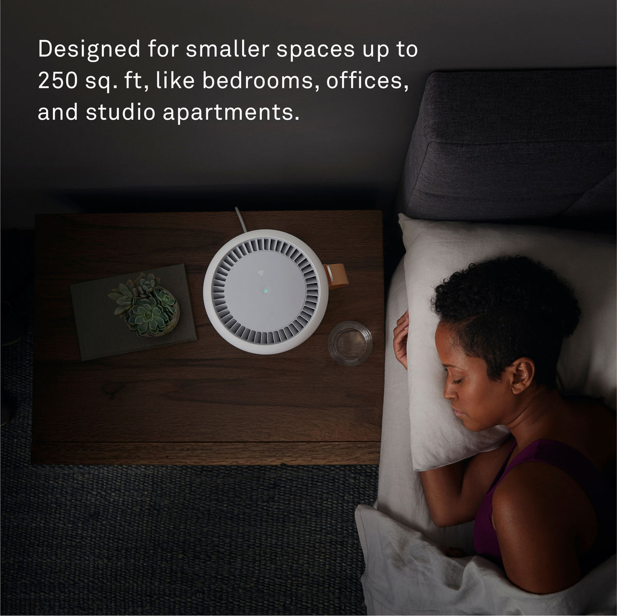  A woman sleeps peacefully in her modern bedroom next to a Molekule Air Mini+ air purifier on the bedside table. Text reads: Designed for smaller spaces up to 250 sq. ft, like bedrooms, offices, and studio apartments.