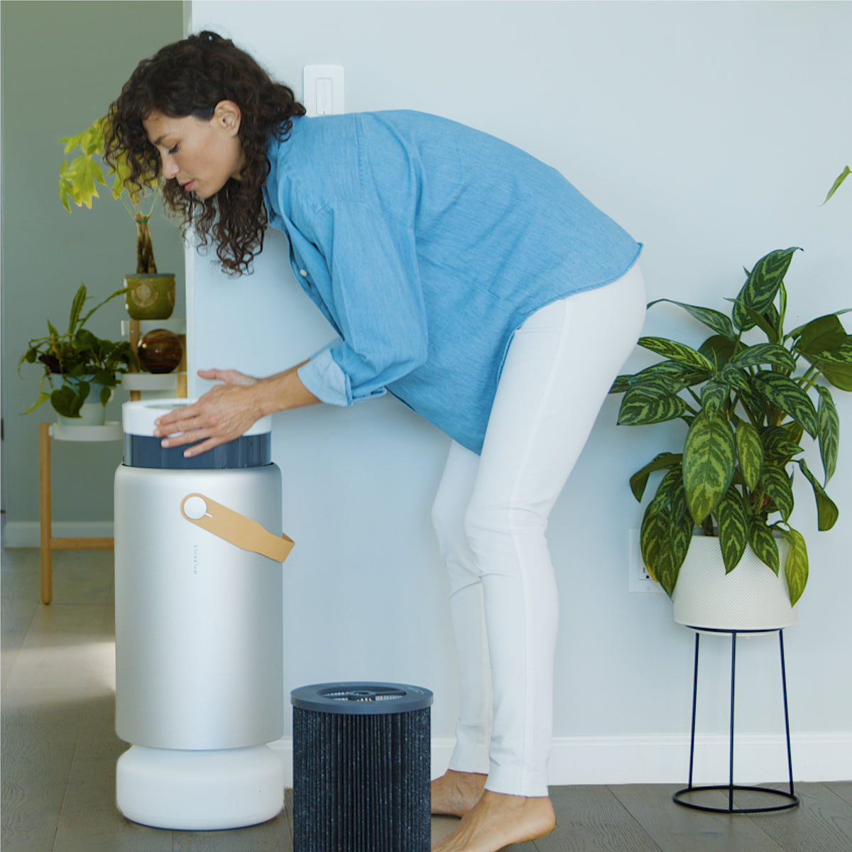 Woman removing the top of Air Pro air purifier to change filter.